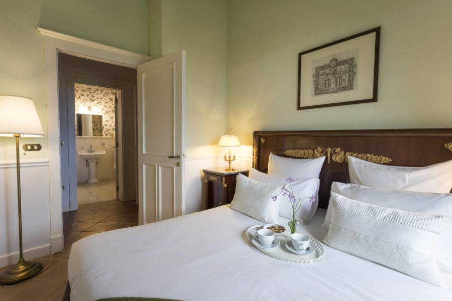 The green double bedroom in front of the flowered bathroom The green double bedroom in front of the flowered bathroom in Casale dell'Ulivo Syracuse Scent of Siciy