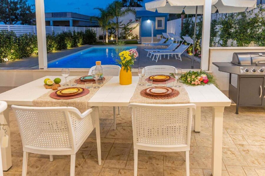 Elegant outdoor dining area at Villa Blue Oasis, a luxury villa in Sicily with a private pool, sun loungers, and BBQ.
