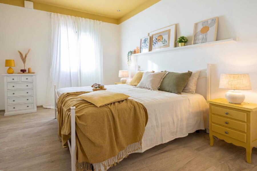 Bright and cozy bedroom at Villa Blue Oasis, a stunning Sicily luxury villa, featuring warm yellow and white tones, stylish décor, and a serene ambiance.
