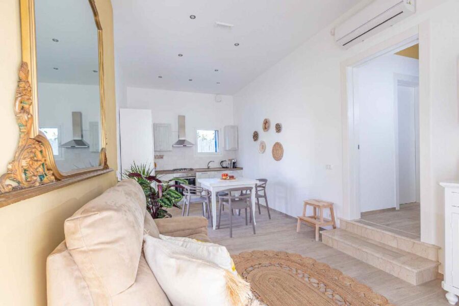 Bright and elegant living space at Villa Blue Oasis, a Sicily luxury villa featuring a cozy sofa, modern kitchen, and Mediterranean-inspired décor.