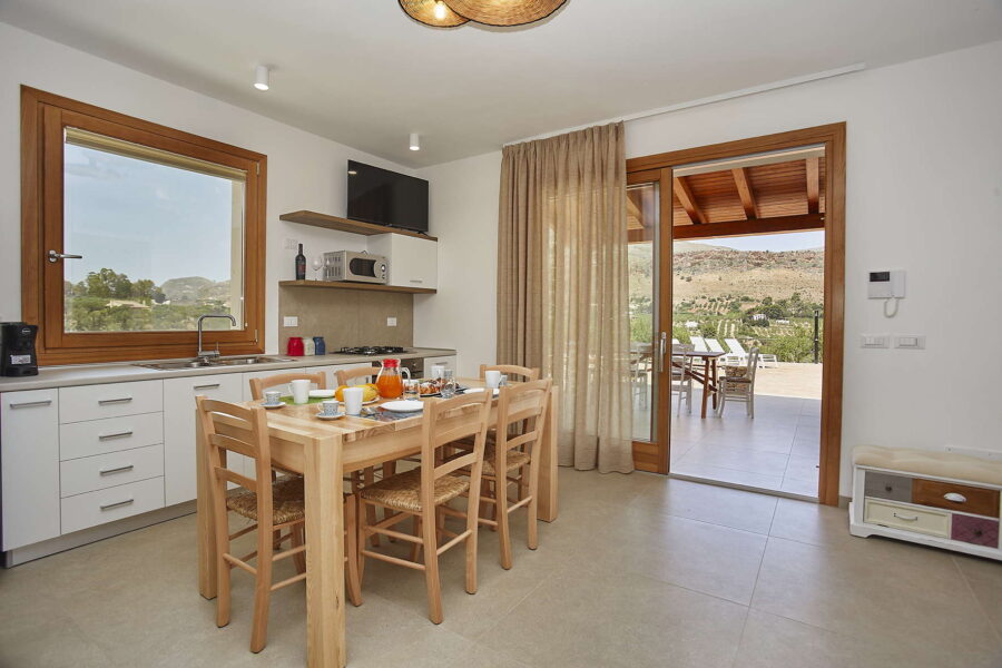 VillaPietraDorata-CastellammareDelGolfo-BrightKitchenDiningAreaWithTerraceAccess-ScentOfSicily Bright Kitchen and Dining Area with Terrace Access at Villa Pietra Dorata – Sicily Luxury Villas