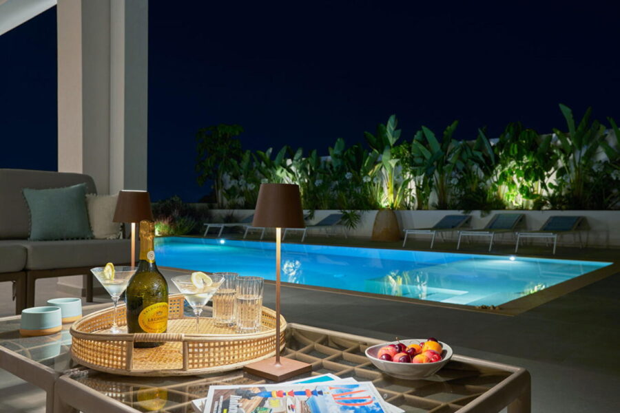 Night view of poolside with drinks and plants at Azure Essence villa in Sicily