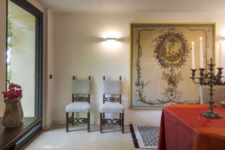 Antique-style dining room at Villa Selvira, a Sicily luxury villa, featuring ornate chairs, classic artwork, and soft candlelight.