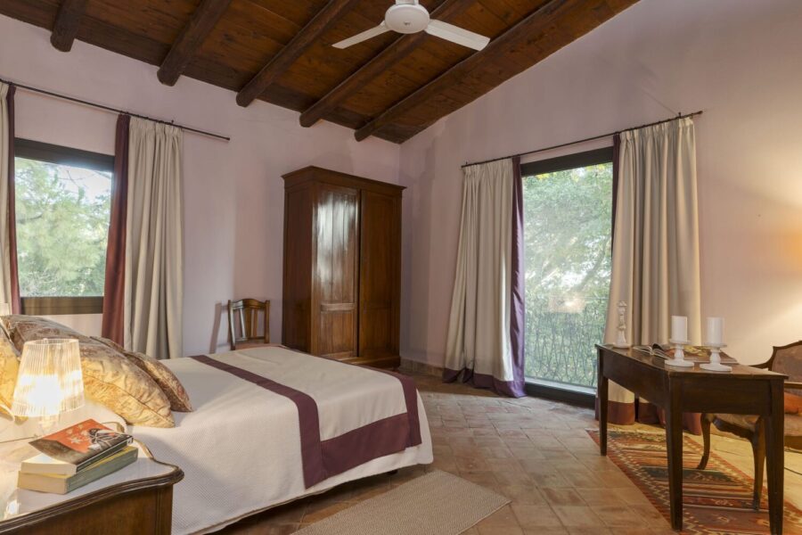 Charming bedroom with wooden ceiling and garden views at Villa Selvira, a Sicily luxury villa with pool.