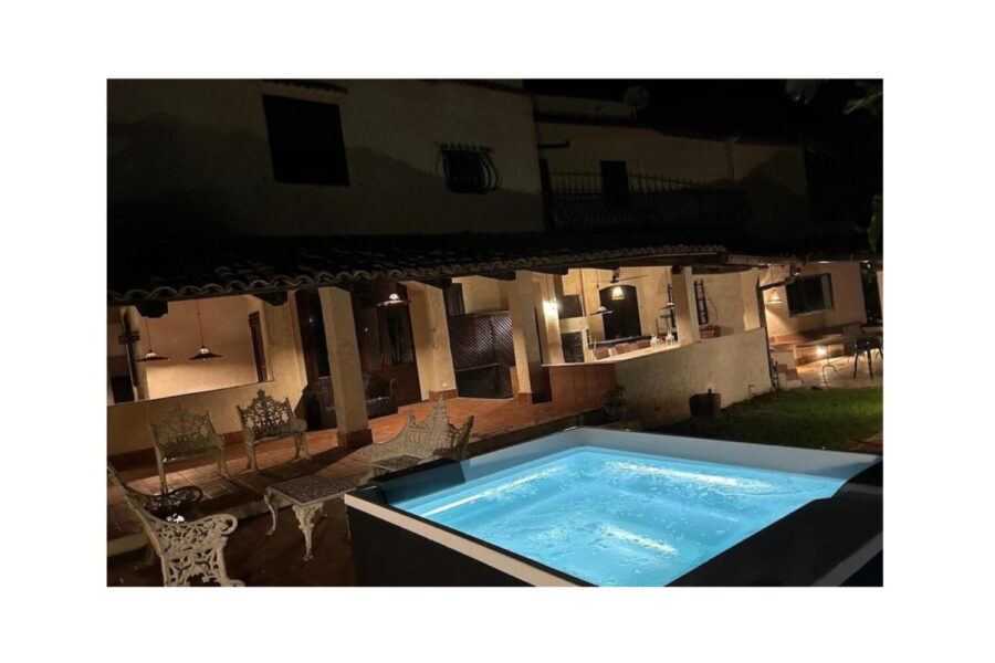 Elegant Night View of Villa Fontane Bianche with Illuminated Jacuzzi – Sicily Nighttime view of Villa Fontane Bianche in Sicily featuring a glowing Jacuzzi and traditional outdoor lounge area.